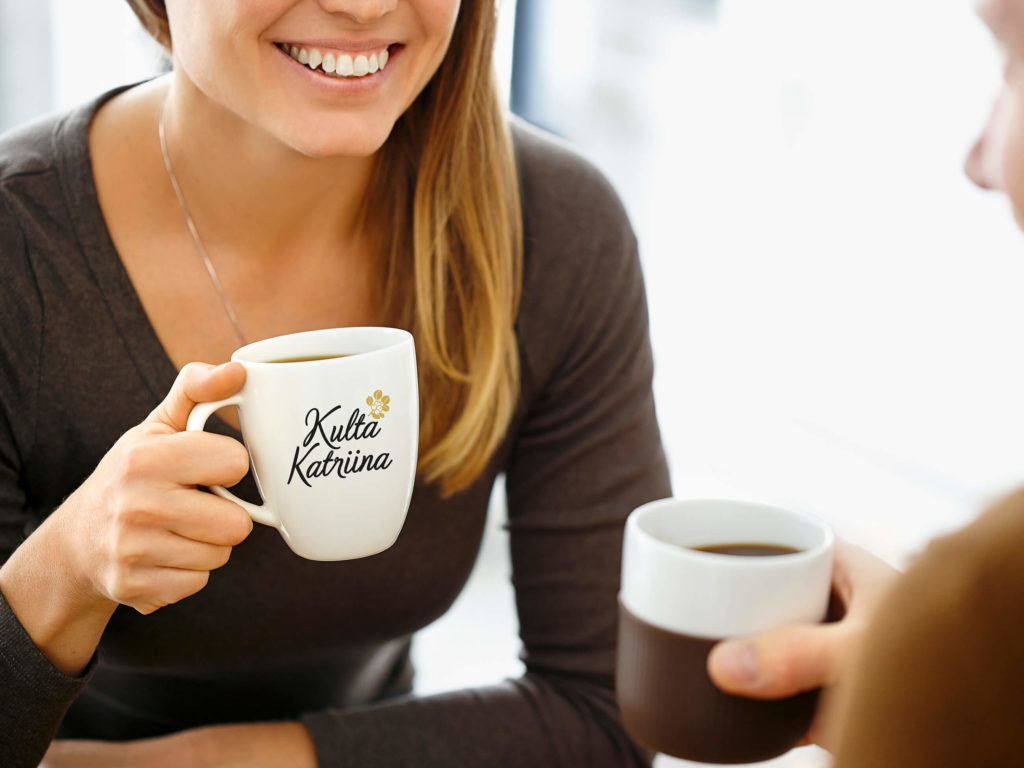 Nainen ja mies kahvilla Kulta Katriina logo